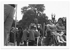 Brad Lomax, center, next to the activist Judy Heumann at a rally in 1977 at Lafayette Square in Washington.Credit...HolLynn D'Lil